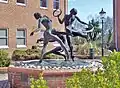 Three women in dark form swirling in evocative poses