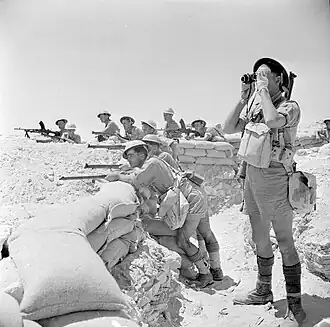 British soldiers in khaki drill uniforms, including shorts, in the Western Desert in 1942.