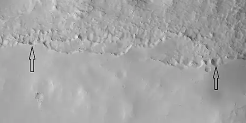 Close view of mantle, as seen by HiRISE under HiWish program. Arrows show craters along edge which highlight the thickness of mantle. Location is Ismenius Lacus quadrangle.