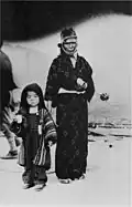 A mother and her child leaving the first-aid station after receiving rations