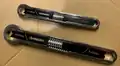 A pair of adjustable wrenches of a box-end style.
