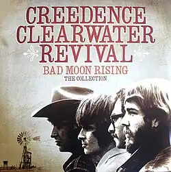 A monochrome image of the band members, with a rural background