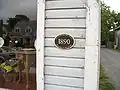 A plaque on the Historic Bellport Museum and Exchange Shop on Bell Street shows the old name of the historic district.