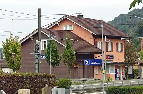 Two story salmon-colored building with adjoining freight house