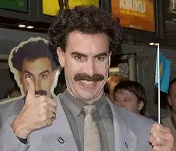 Baron Cohen giving a thumbs up, dressed as Borat