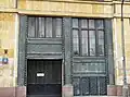 An entrace decorated with copper metal sheets with plant motives
