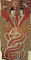 The two conjoined figures are Fuxi and Nüwa holding a compass and a ruler respectively; a painting discovered at the Astana Graves. Burial objects in the Turpan region often display a strong Chinese influence as Chinese Han culture was introduced early in its history.[25]