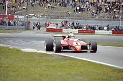 Red Ferrari racing car exiting a corner during a race