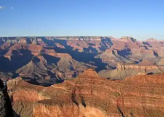O'Neill Butte, (above Supai Group 'redbeds'), on ridgeline from Yaki Point; (Newton Butte prominence off photo, right) View northeast, with Cape Royal (point) on Walhalla Plateau (Kaibab Plateau), and flat-top of Wotans Throne and Vishnu Temple prominence. (from Yavapai Point, west of Yaki Point, South Rim)
