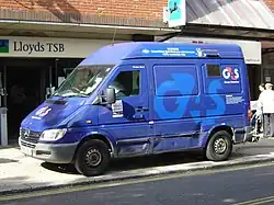 a purple armoured van parked at the roadside