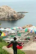 Haenyeo carrying baskets toward the sea in Ulsan
