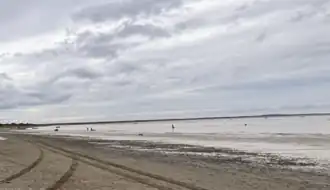 Kvichak Bay at low tide, with fishermen in the distance