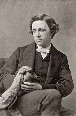 clean-shaven white man with medium-length dark hair, seated
