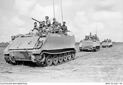 Black and white photo of three tracked military vehicles