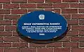 Plaque marking the site on the side of the former Genoa Packing Co. building.