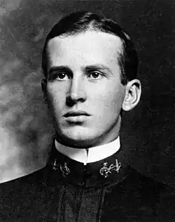 Black and white portrait from the torso up of a young man in a shirt
