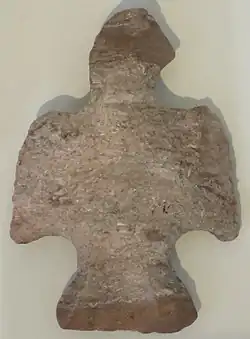 Flaked, banded light brown stone, shaped like a displayed bird.
