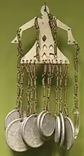 A pendant made of Japanese coins, brass, aluminum and glass