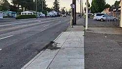 Image 36A patched road rut at a Portland Oregon bus stop. During the summer this part of the road will be hot and combined with a bus’s high ground pressure will compress and deform part of the road. Due to the lower elevation from the driveway, a large portion of the buses weight leans on one wheel causing damage to the road. Despite the repairs, you can see the patch is already damaged. This happens yearly. (from Road surface)