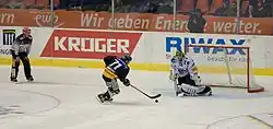 Munro is the goaltender defending against skater Sébastien Bordeleau as Bordeleau aims to shoot the puck in a penalty goal