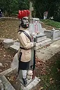 A sepoy statue standing by a grave; these statues were believed to act as guardians to the deceased[110]