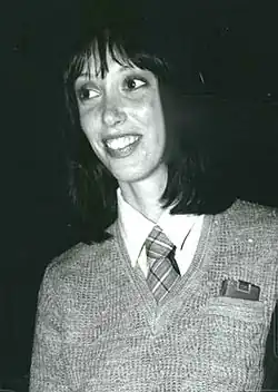 Duvall glancing to her right and smiling
