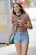 Smiling girl wearing orange, black and white striped shirt