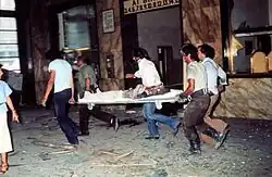 More passers-by carrying a stretcher