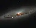 NGC 4845's glowing centre hosts a gigantic version of a black hole.[10]