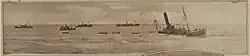 B&W image of a half-sunken ship stranded just off shore