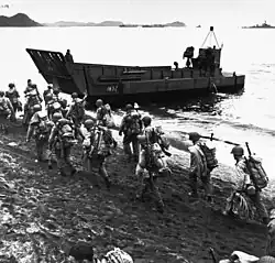 Troops march up the beach at Adak, during pre-invasion loading for the Kiska Operation, 13 August 1943.