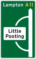 Junction ahead of a primary route with a non-primary route through a town or village that has been by-passed