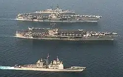 John F. Kennedy and Saratoga, a Forrestal-class carrier. Note the differences in island and aircraft elevator configuration.