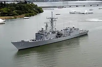 Sailors aboard USS Crommelin (FFG-37) man the rails as the ship passes the Arizona Memorial in Pearl Harbor, 12 May 2004.