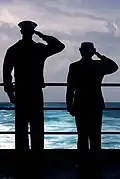 YNSN Jessica Gardner and YNSN Whitney Utter salute as USS Kitty Hawk (CV-63) passes over final resting spot of USS Lexington (CV-2).