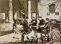 Vietnamese men playing Tổ tôm, a Vietnamese card game, on a sập.