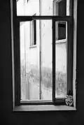 Window of occupied building, with a Guy Fawkes mask placed next to it. Guy Fawkes masks have often been used as a symbol of resistance in the Occupy movement.